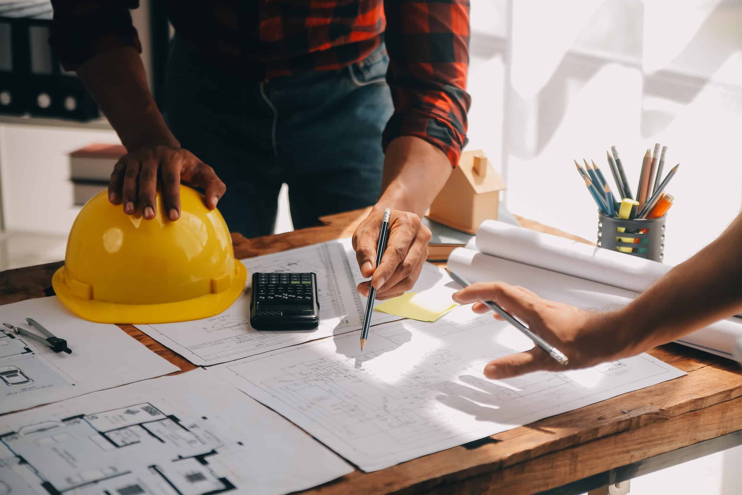 Planification architecturale sur table avec casque jaune.